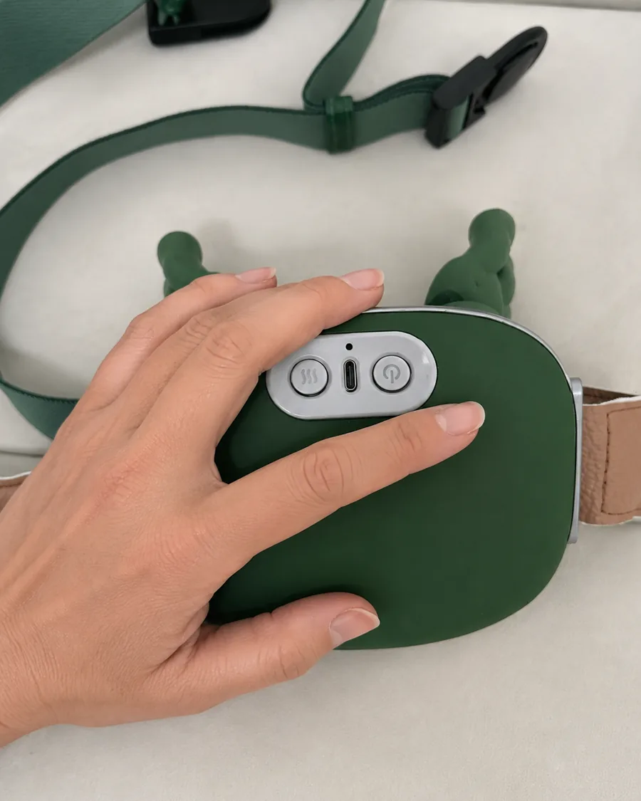 Une main posee a plat sur la coque du chale de massage eteint, cadrage serre